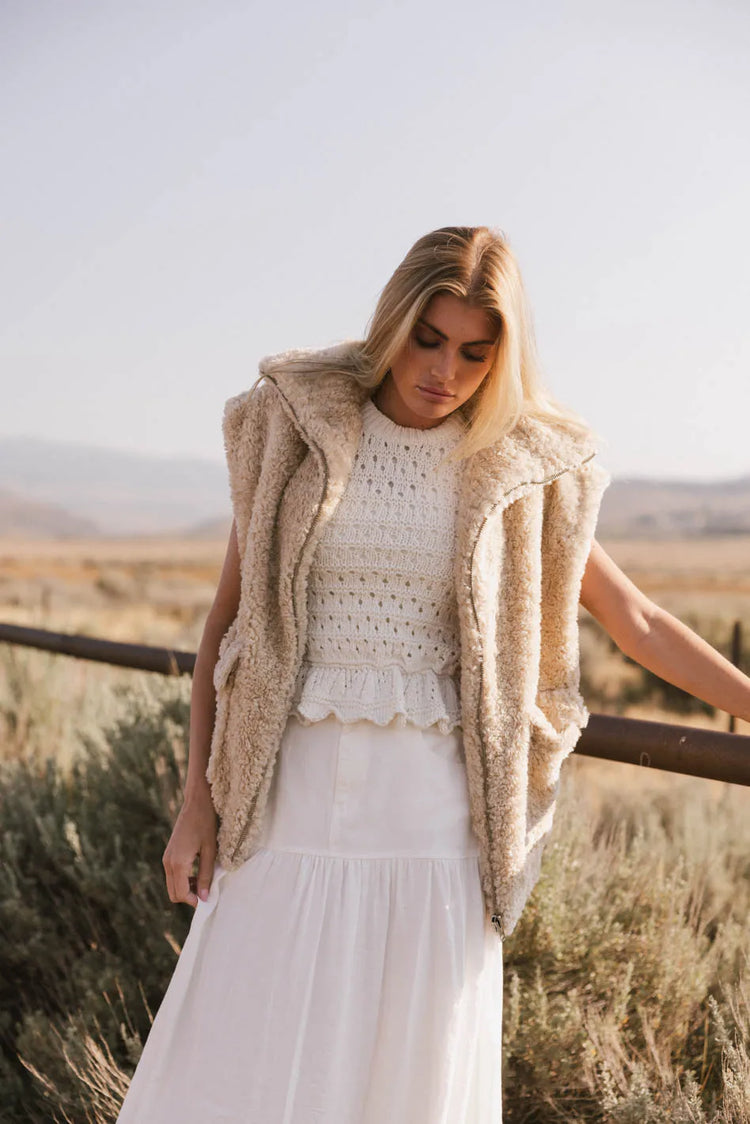 Vest in beige paired with white top 