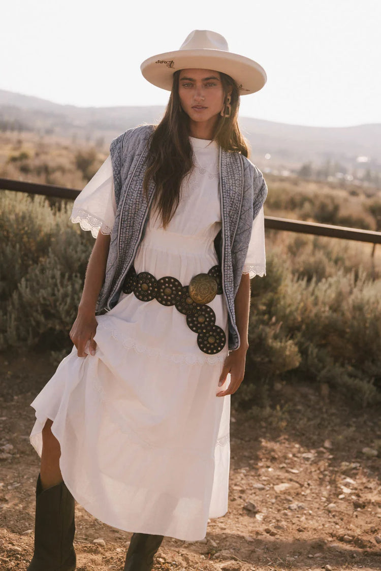 Vest in denim paired with a dress in white 