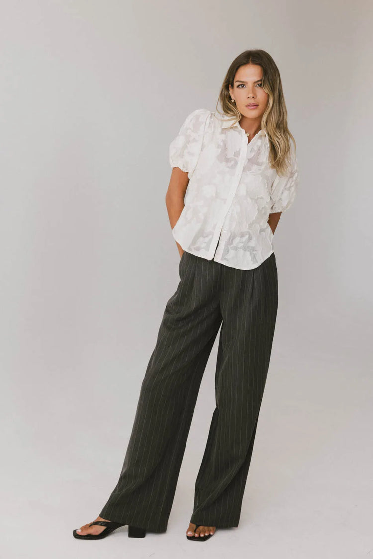 Blouse in cream paired with a dark grey pants 