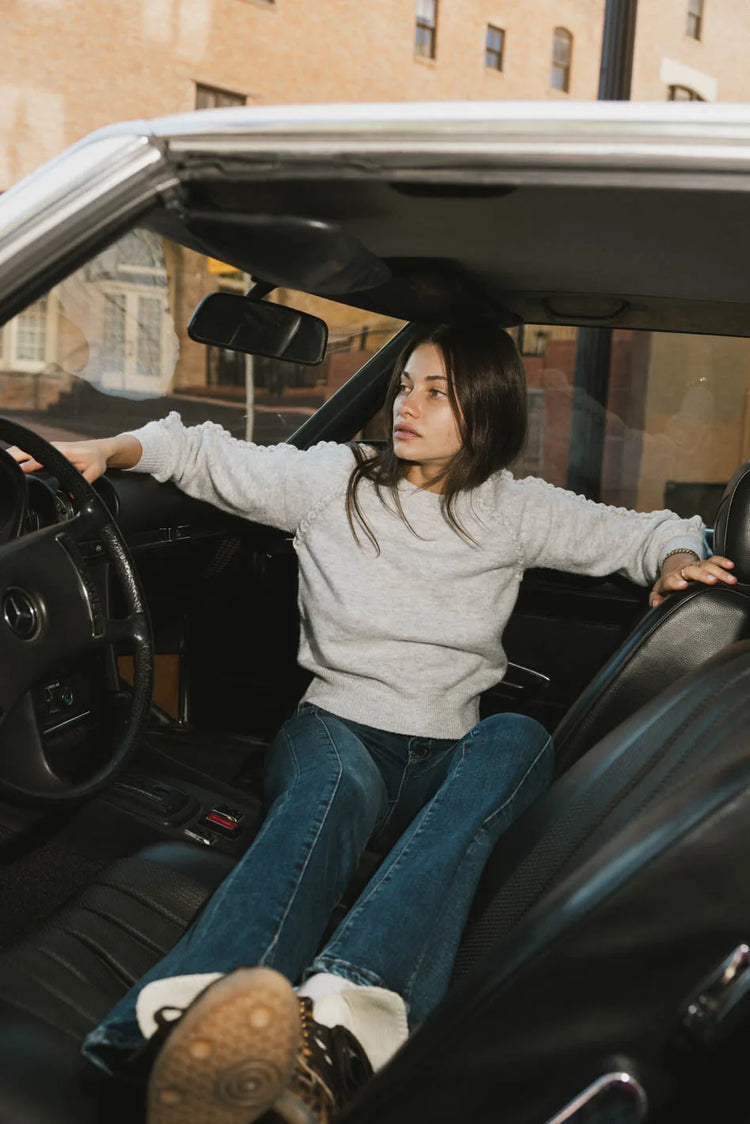 Top in grey paired with a dark denim pant 