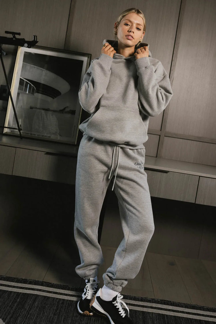 Hoodie in grey paired with grey sweatpants 