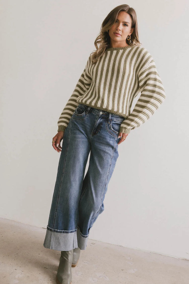 Striped sweater paired with medium wash denim 