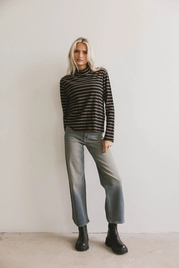 Striped top paired with medium wash denim 