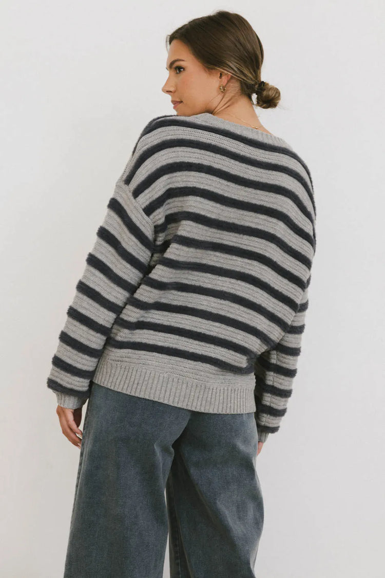 Striped sweater paired with denim in dark wash 