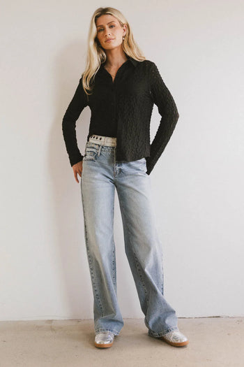 Button up top in black paired with light denim jeans 