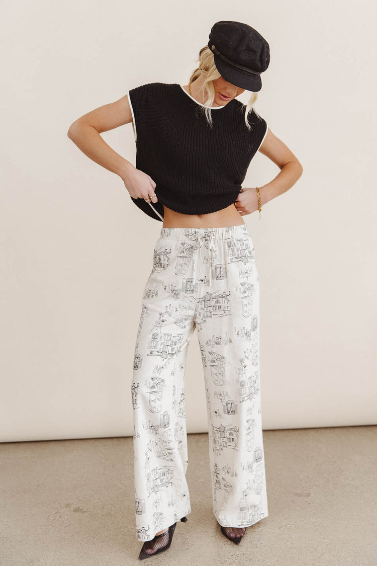 Printed pants in cream paired with a black sweater 