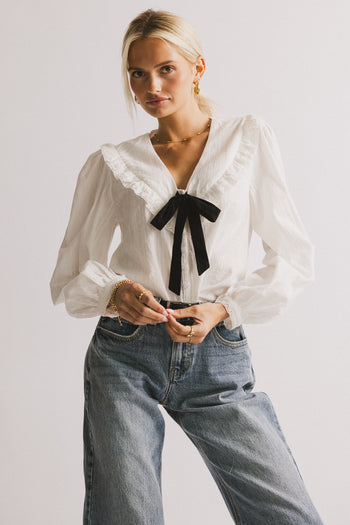 BLACK BOW TIE ON CHEST OF WHITE BLOUSE