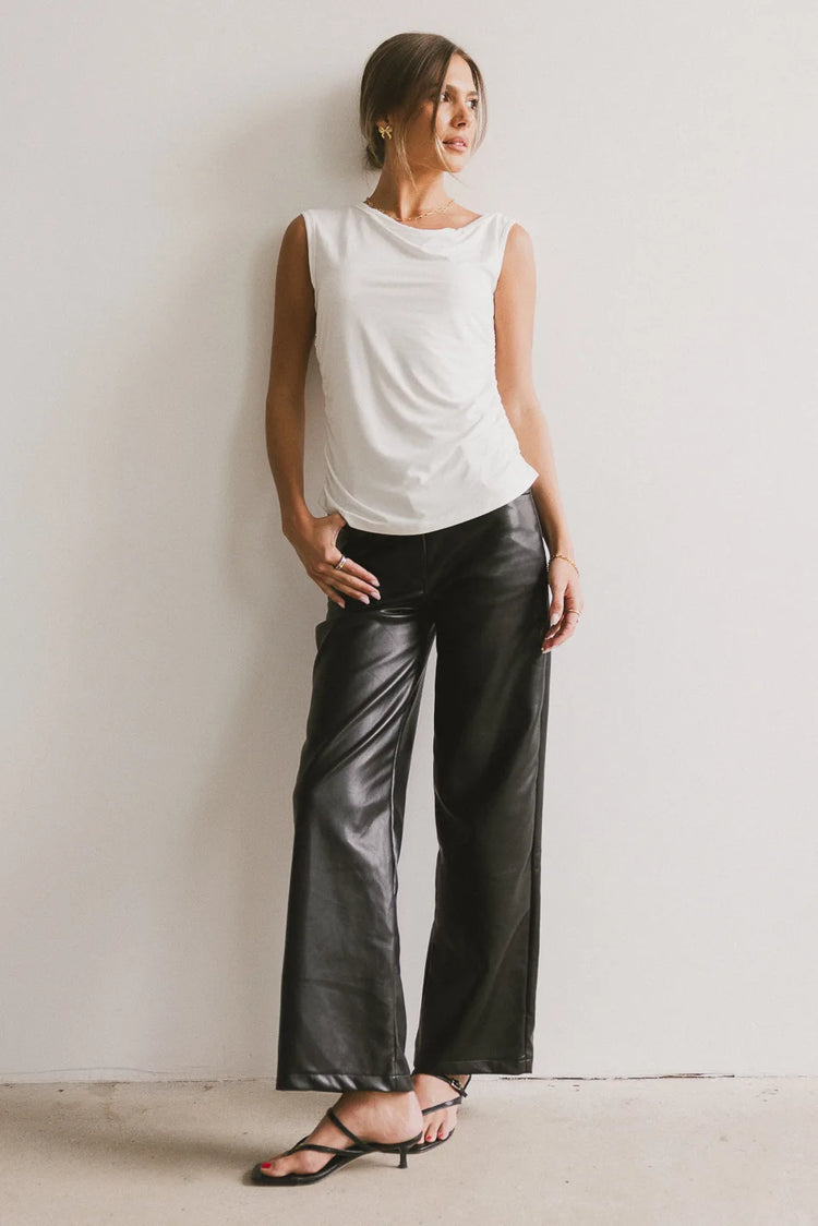 Knit top in white paired with leather pants in black 