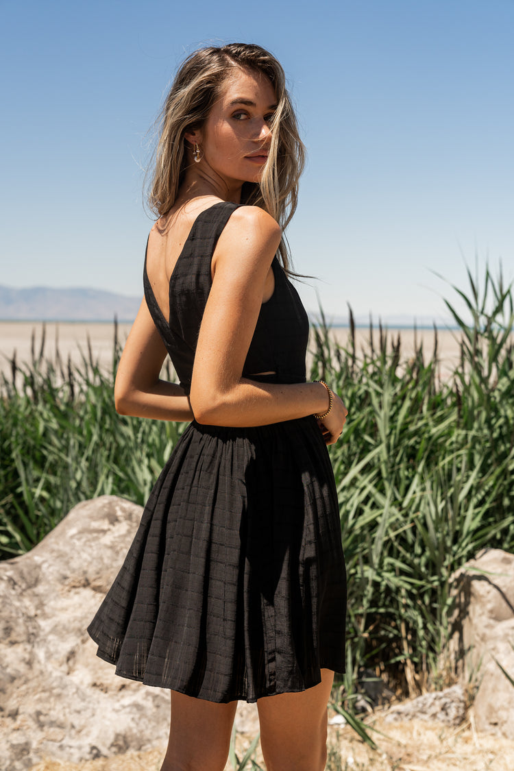 Sleeveless black mini dress with light texture