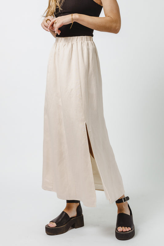 cream linen maxi skirt with side slit paired with black tank and sandals