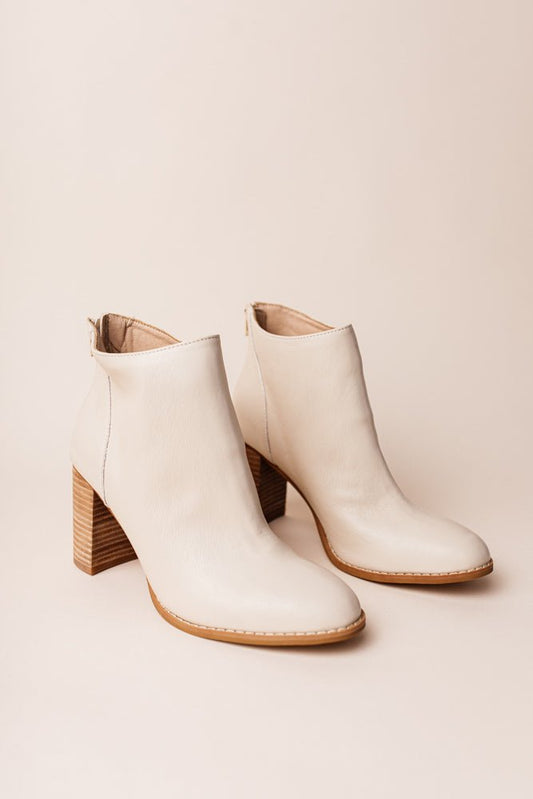 Alexis Heeled Boots in white have a thick black heel and rounded toe. They're ankle height with tan sole.