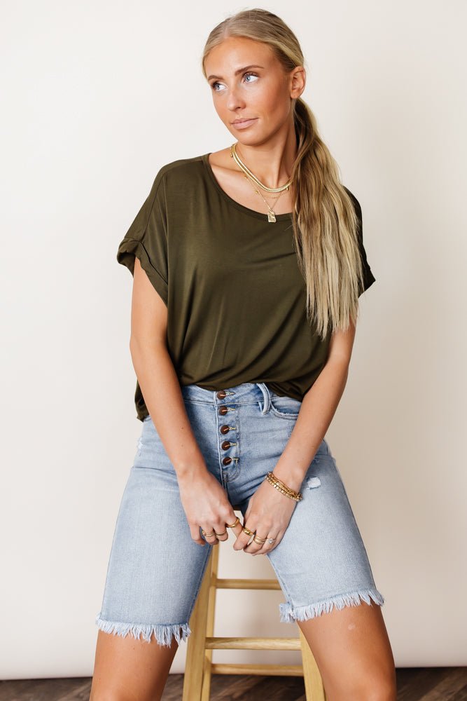 Model wears the Dempsey Rolled Sleeve Tee in Olive with light wash bermudas. Tee has relaxed fit, wide round neck, and short sleeves.