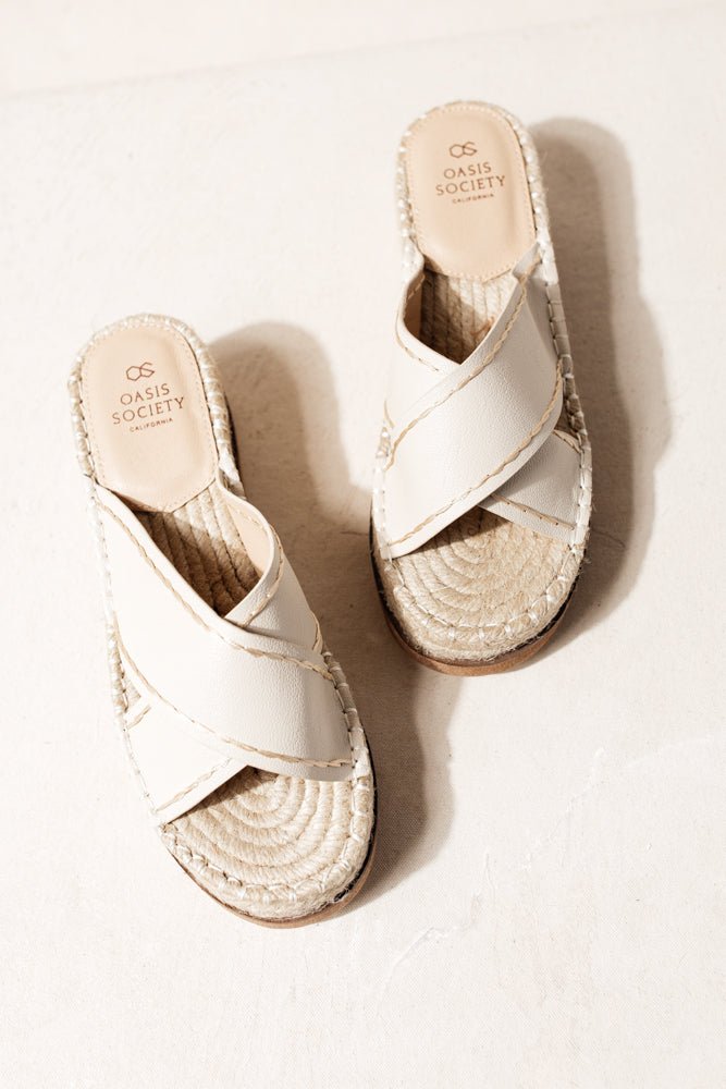 The Lucia Sandals in Beige has espadrille soles and faux leather criss cross straps with beige stitching.