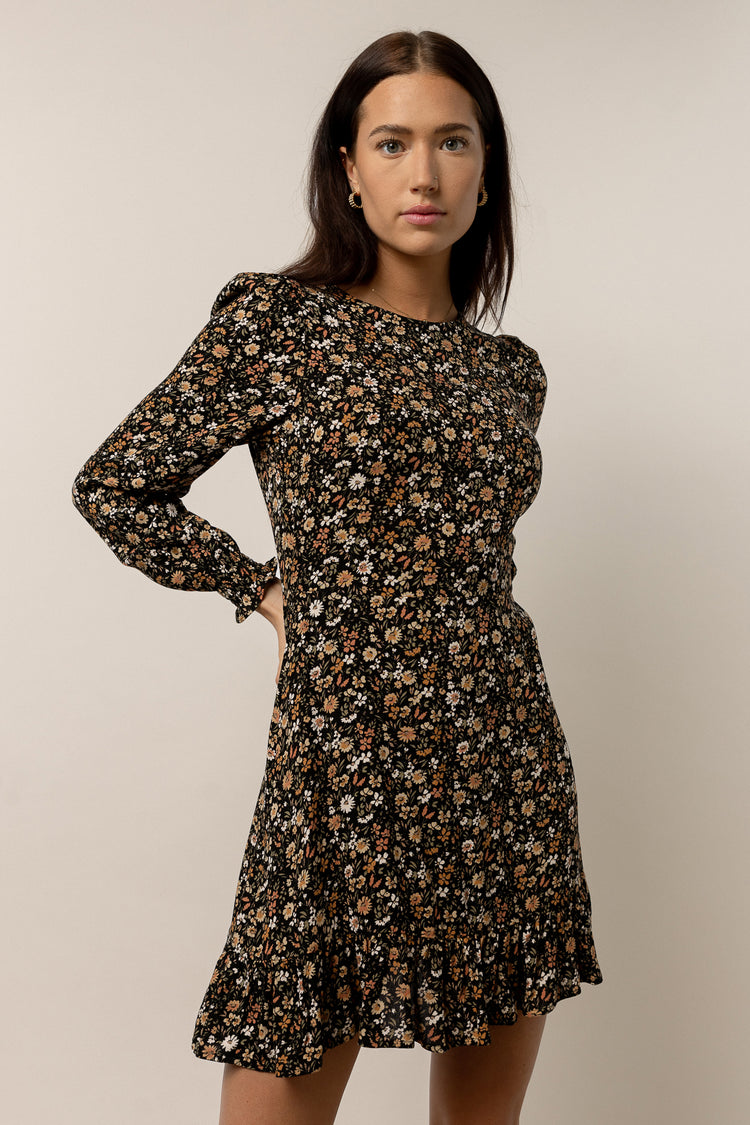 model wearing long sleeve black mini dress with floral pattern