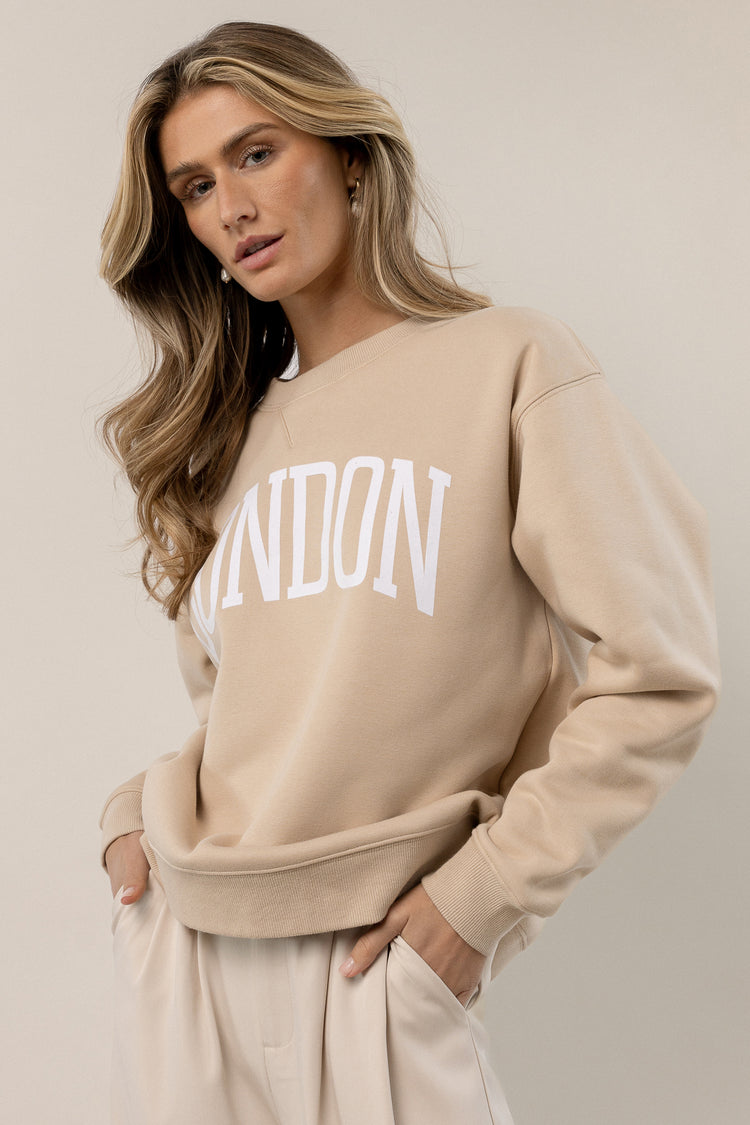 model is wearing london graphic pullover with ivory pants