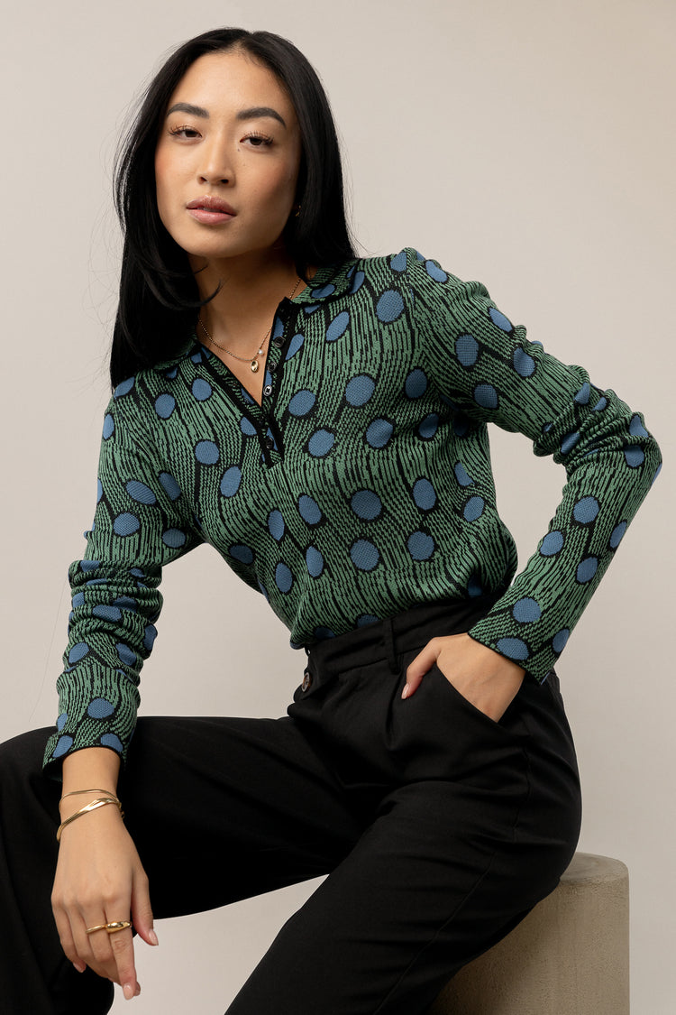 model is wearing printed long sleeve top with collar and black pants