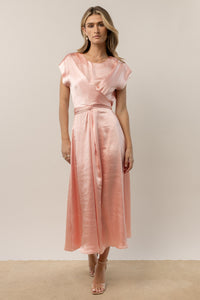 model wearing pink short sleeve midi dress with front crisscross detail