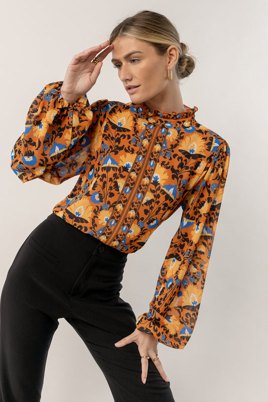 model is wearing printed blouse with black pants