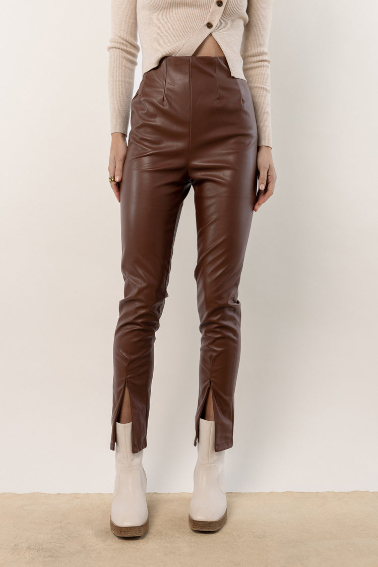 model wearing brown leather pants with ankle zipper