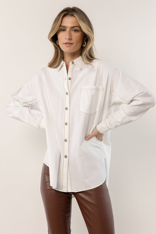 model is wearing stitched button up top with brown leather pants