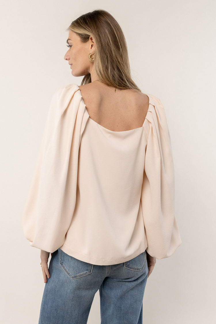 beige blouse with pleated detail