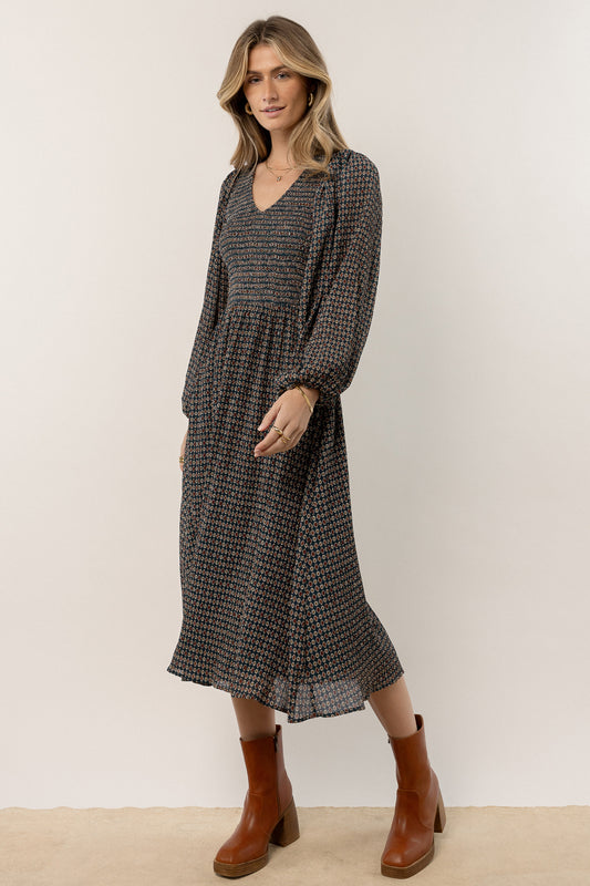 model is wearing printed midi dress with brown boots