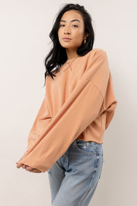 model wearing long sleeve peach sweatshirt