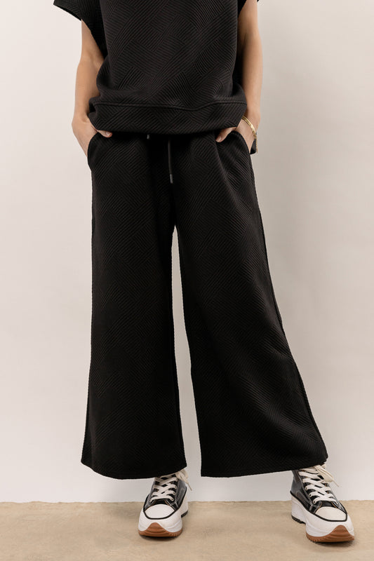 model wearing black wide leg pants
