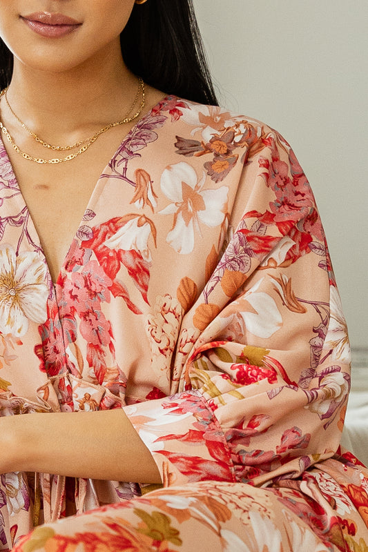 Close up of v neck floral maxi dress pared with gold jewelry