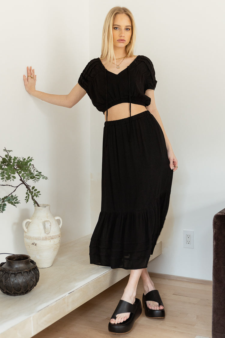 Crop top in black paired with a black midi skirt 