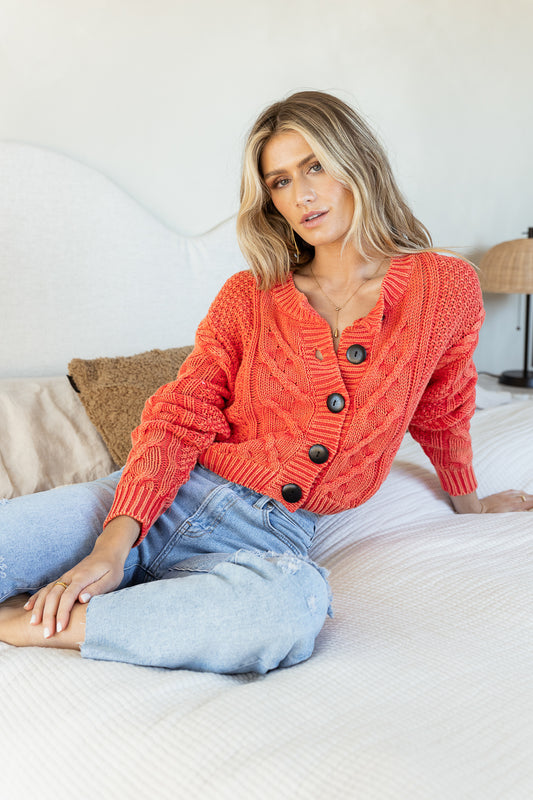 orange cardigan with black buttons