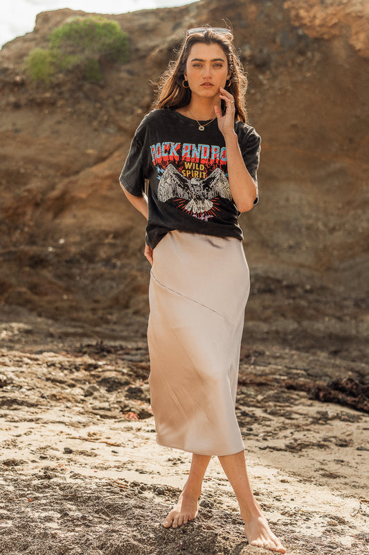 tan skirt with black graphic tee at the beach
