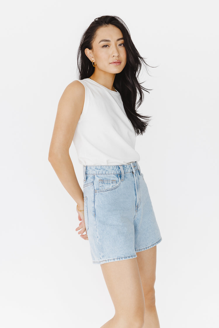 sleeve less white sweater top with light wash shorts