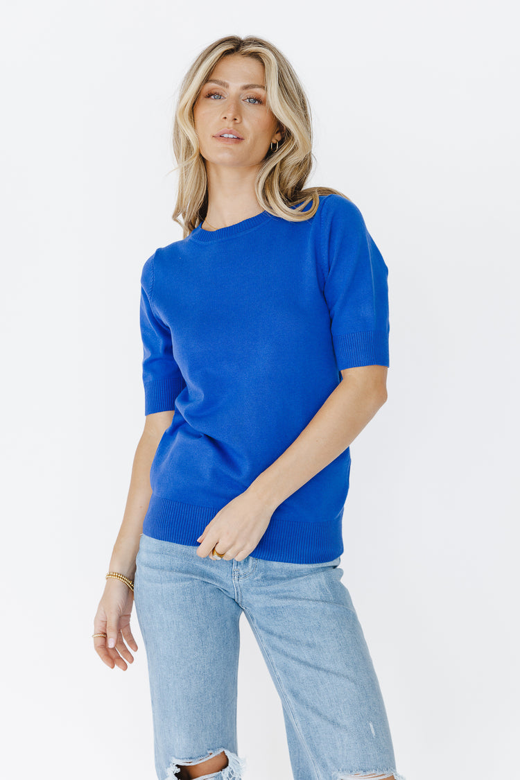 front view of royal blue sweater with gold jewelry 