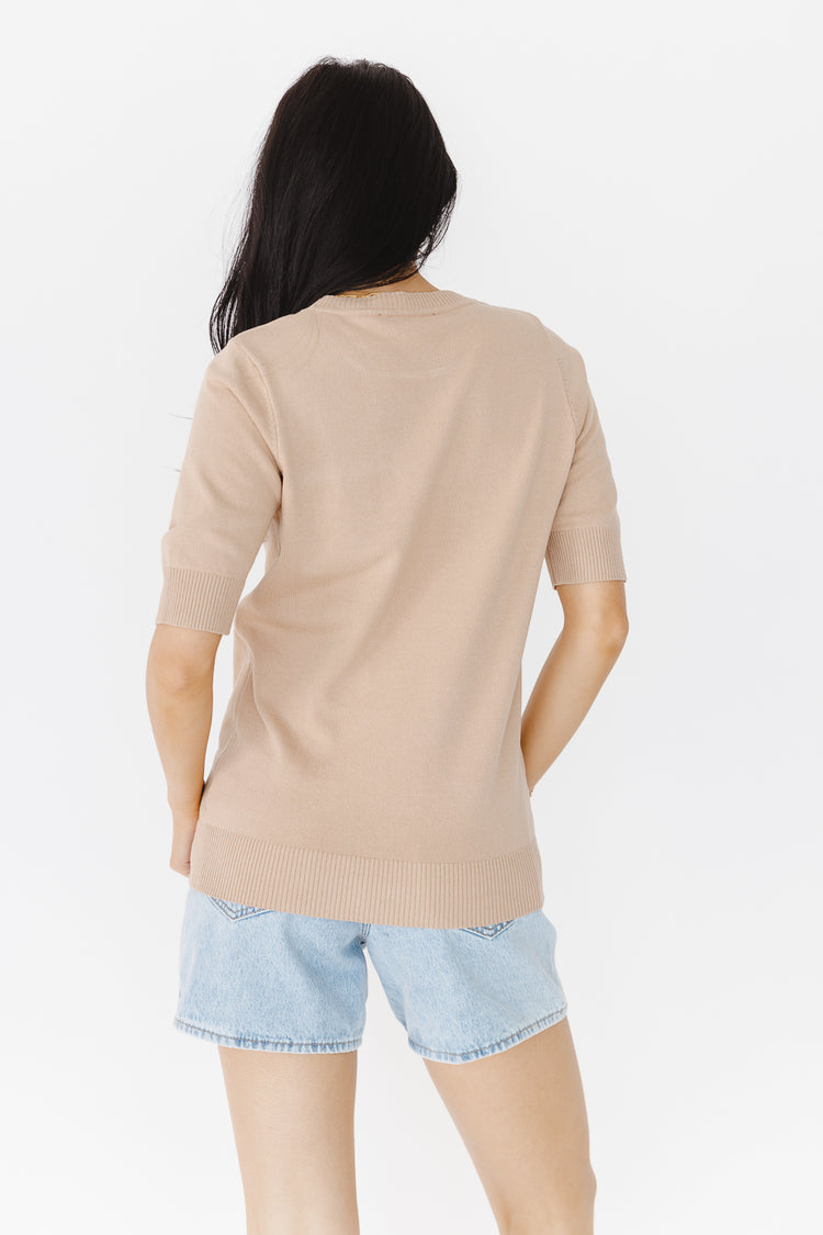 backside of taupe sweater with light wash shorts
