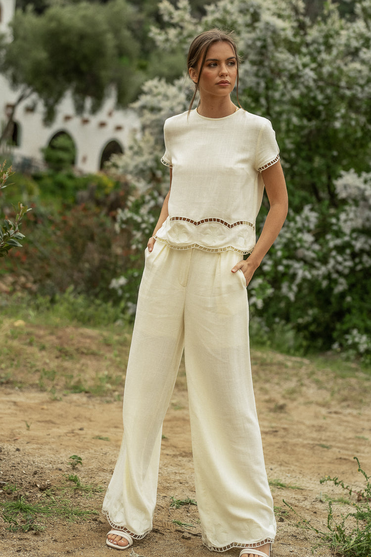 Embroidered pants in cream paired with a cream top 