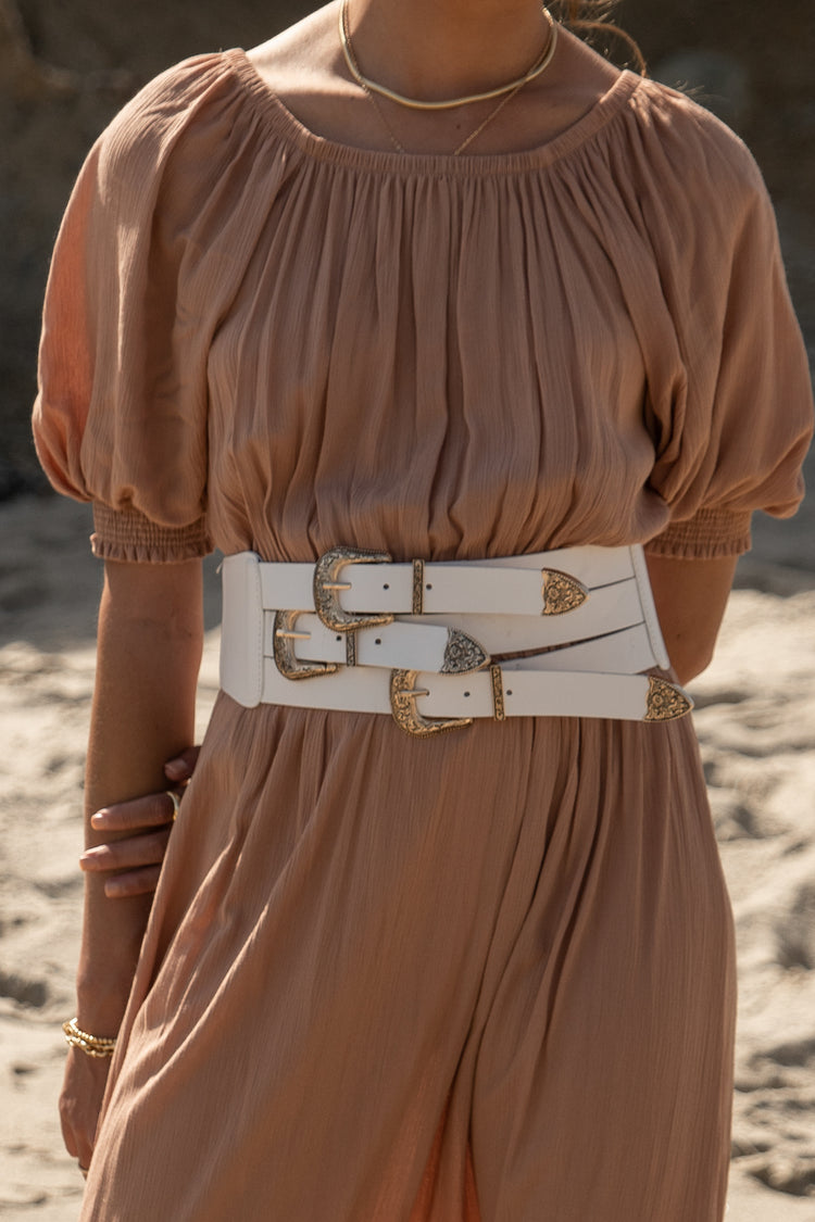 white waist belt with gold buckles