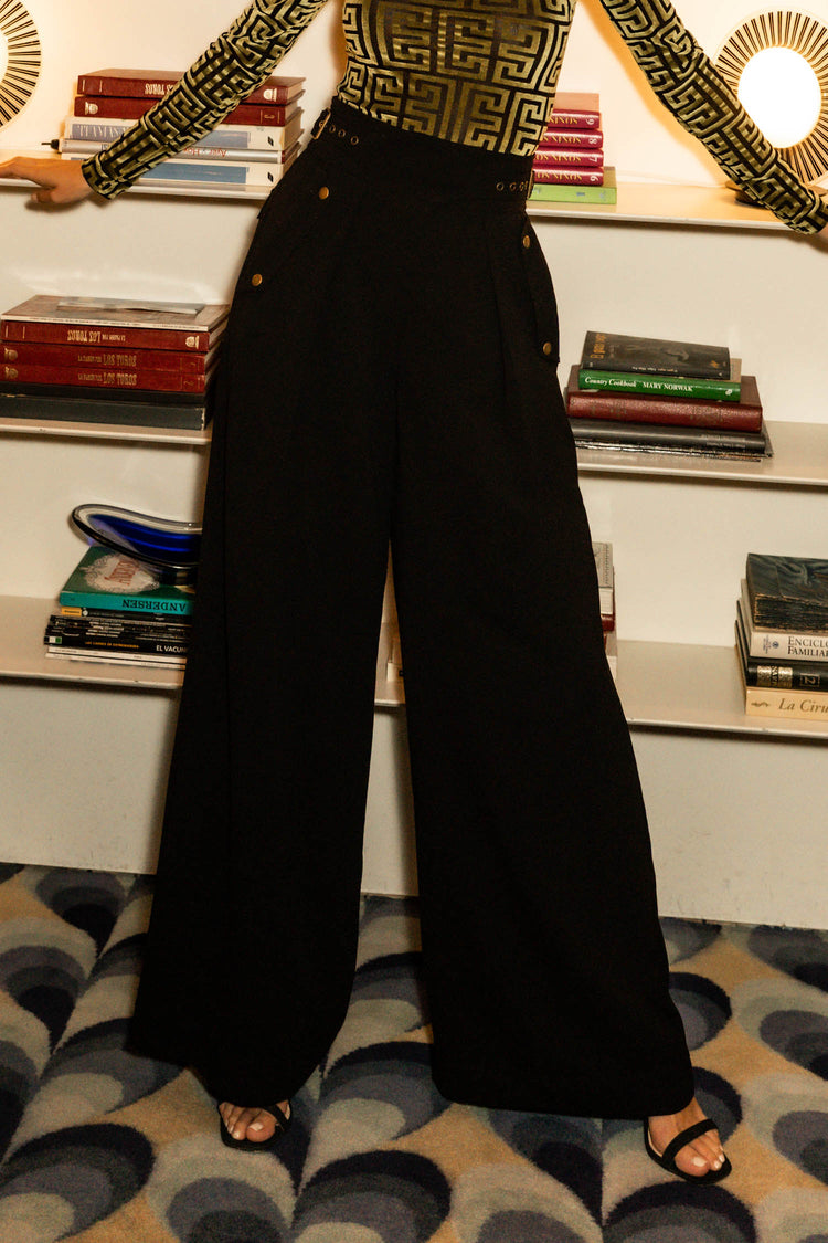 black flowy pants with side buttons and black heels