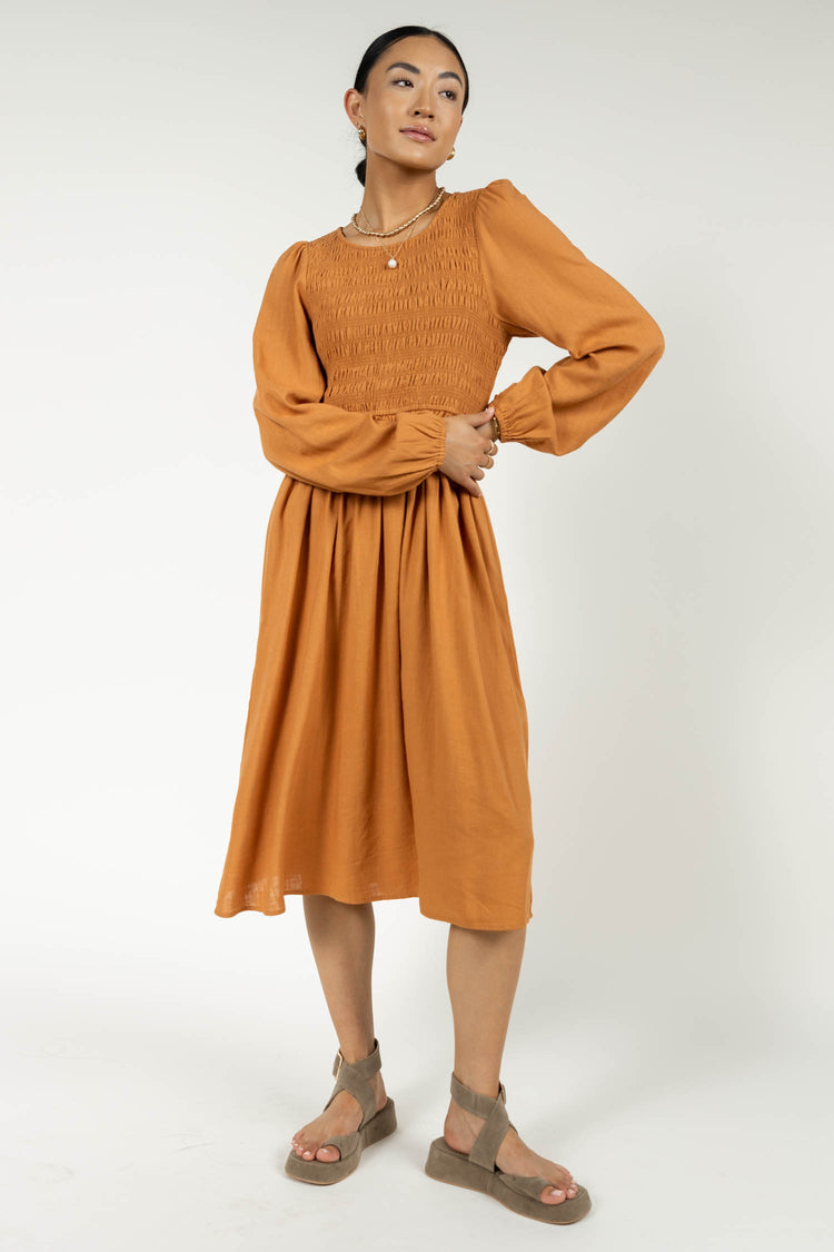rust midi dress with pearl pendant necklace