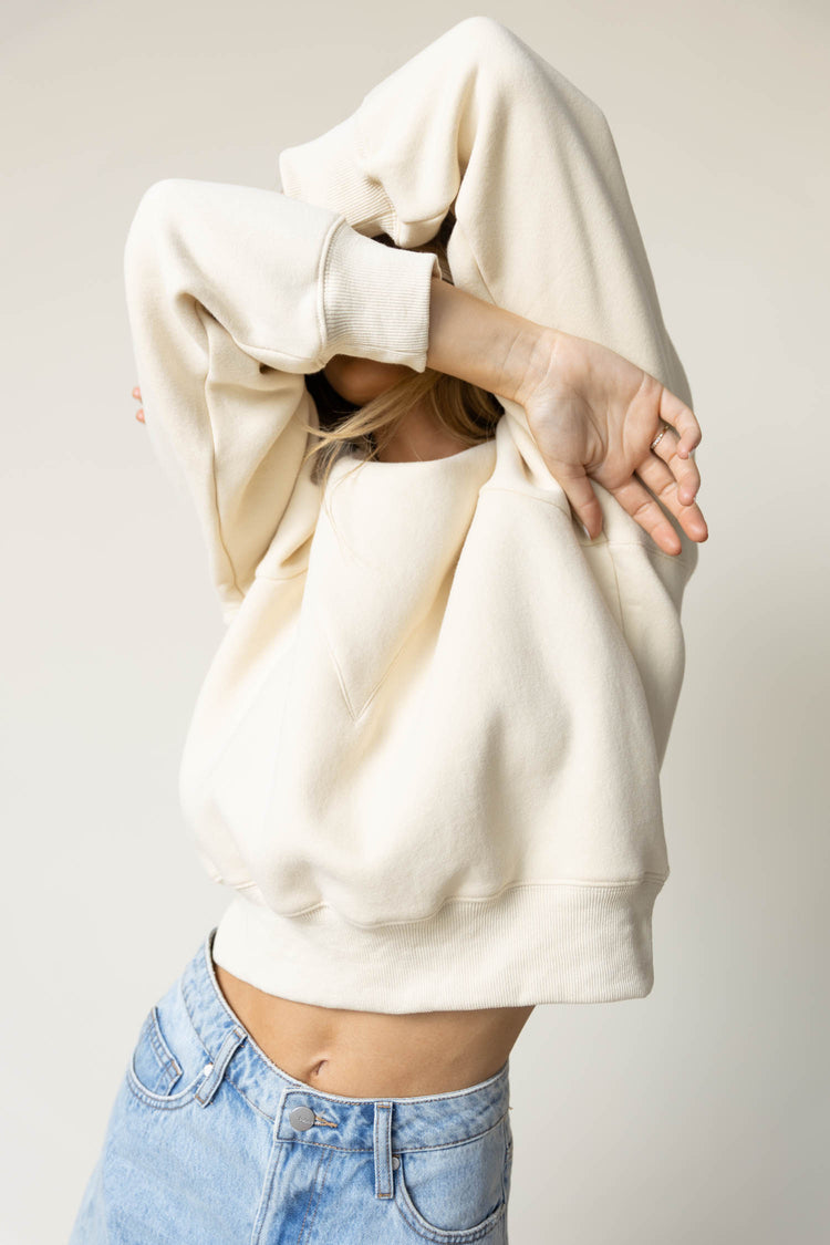 cream pullover paired with light wash shorts