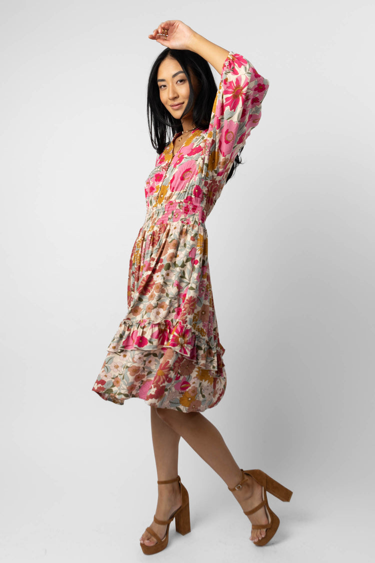 model wearing cream floral midi dress with brown heels