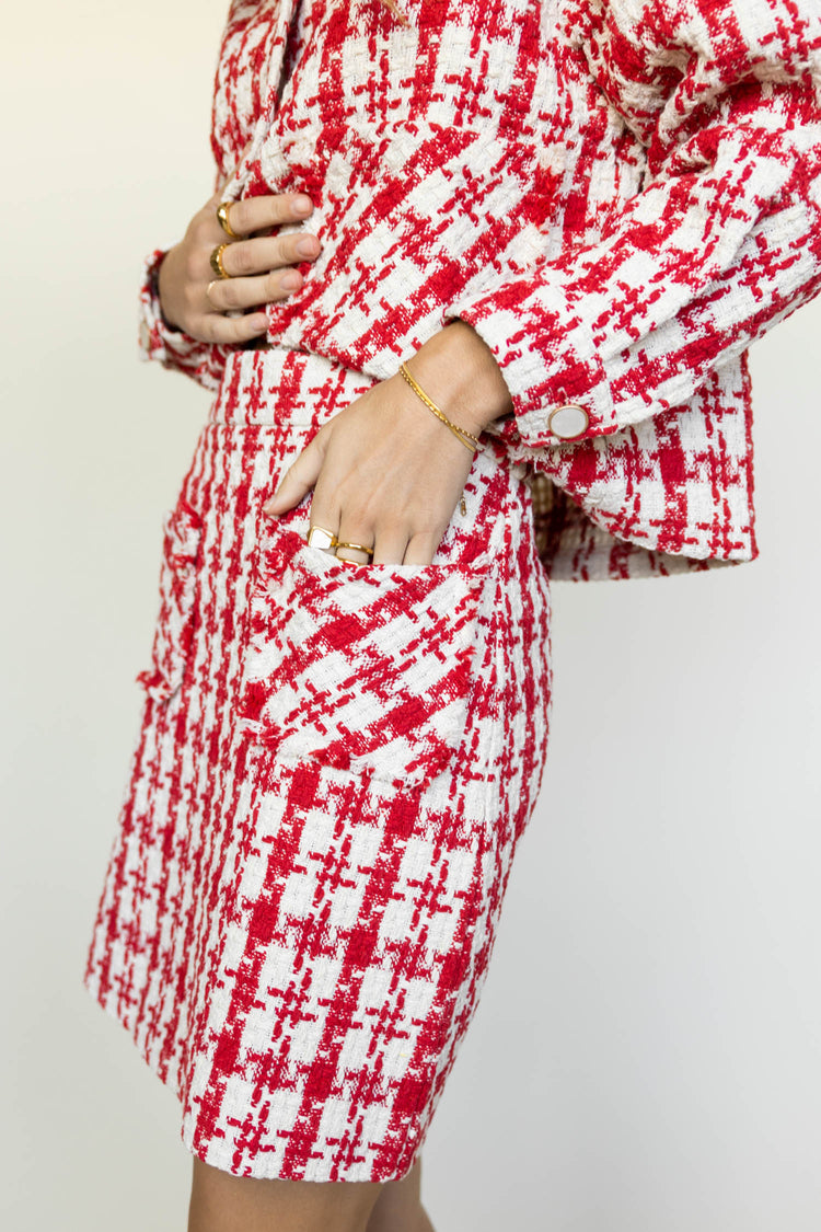 model wearing red and white plaid skirt with two from pockets paired with matching jacket and white loafers