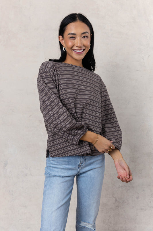 model wearing charcoal striped top paired with light wash denim