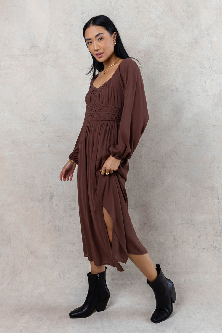 model wearing long sleeve brown dress with black boots