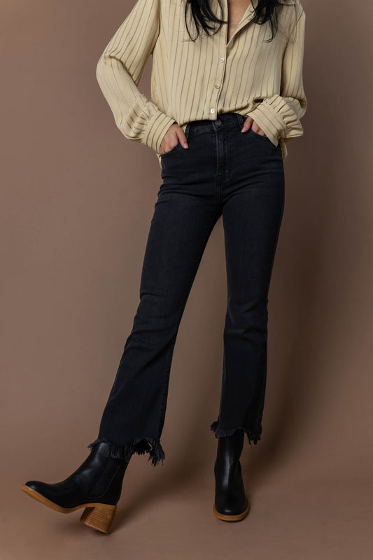 model wearing black straight leg jeans with raw jagged hem paired with black boots