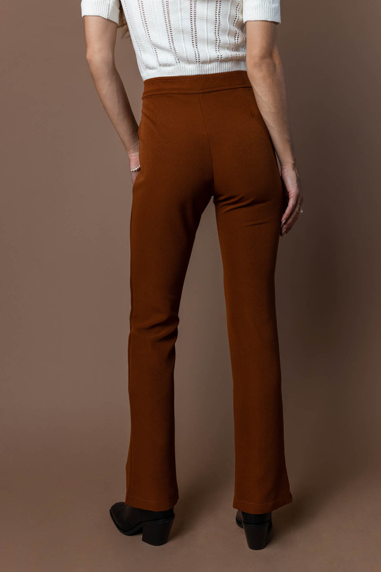back view of brown dress pants and white crop top