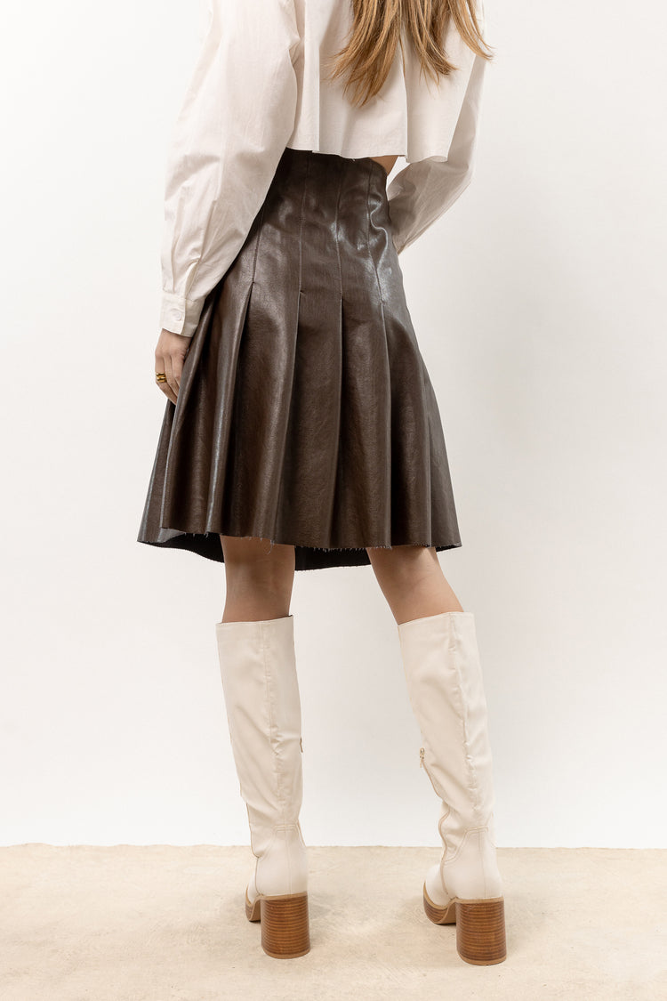 brown pleated leather skirt paired with knee high white boots