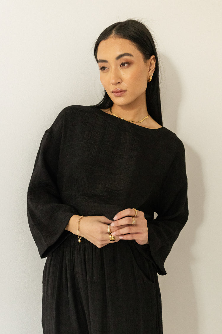 oversized lounge black top pared with gold jewelry 
