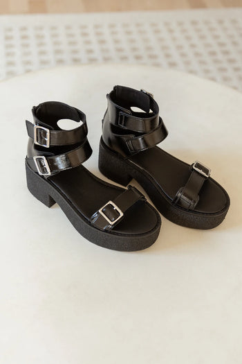 black platform sandals with silver buckle details