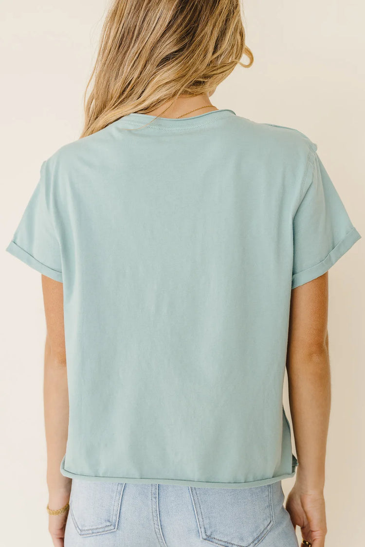 sage green top with rolled sleeves